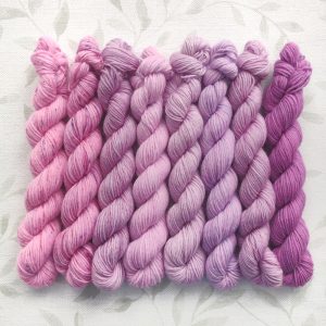 hand dyed 4 ply 8 x 20g mini skein set in shades of pink and purple called Lilac Blossoms.