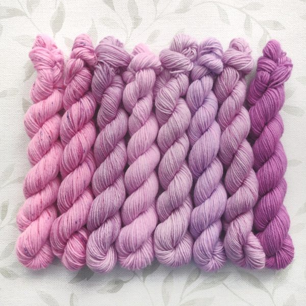 hand dyed 4 ply 8 x 20g mini skein set in shades of pink and purple called Lilac Blossoms.