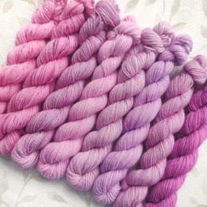 hand dyed 4 ply 8 x 20g mini skein set in shades of pink and purple called Lilac Blossoms.