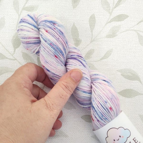 hand dyed 4 Ply 50g yarn in shades of pink, blue and purple with pink speckles called Pixie Confetti.